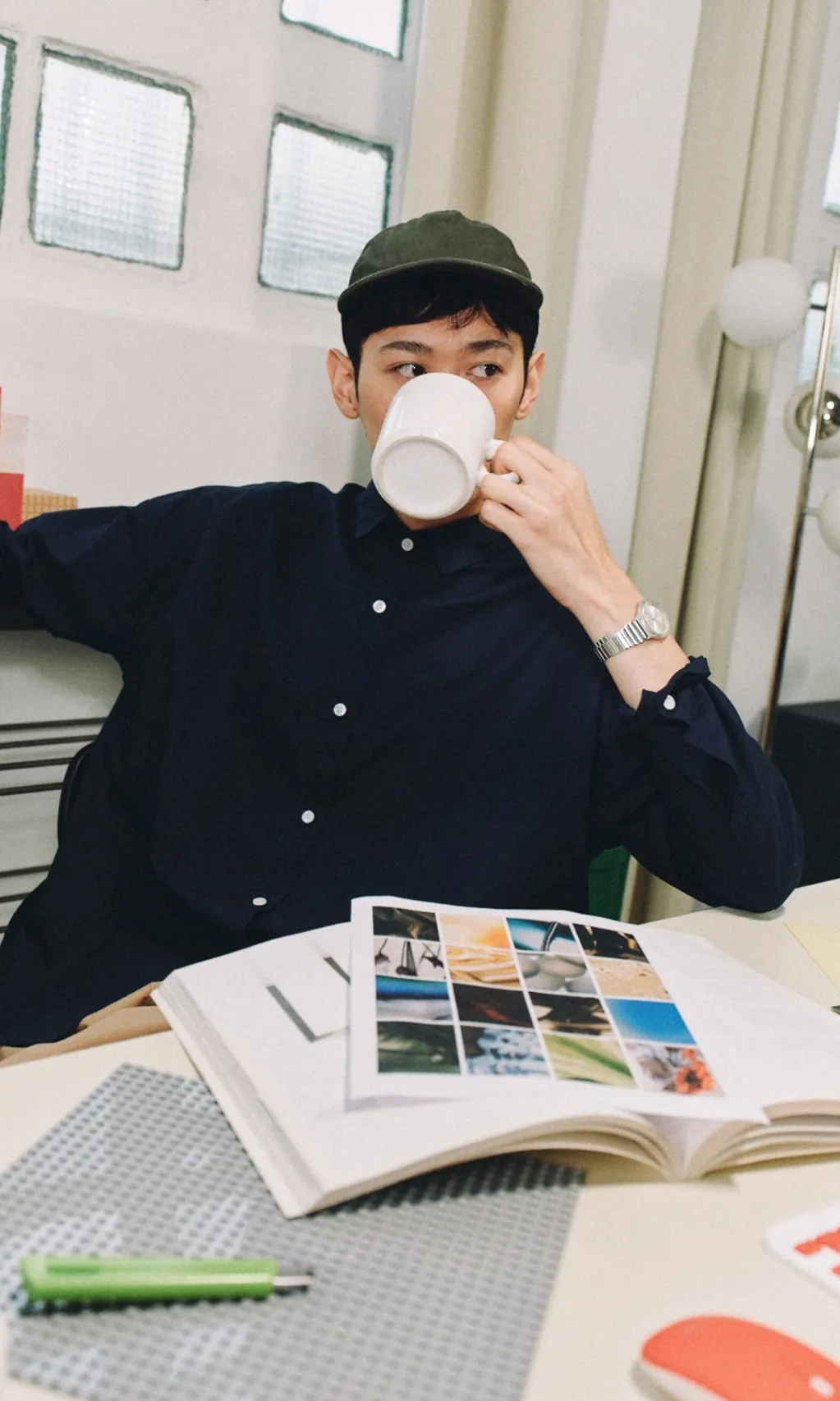 Man met pet drinkt koffie aan zijn werkplek