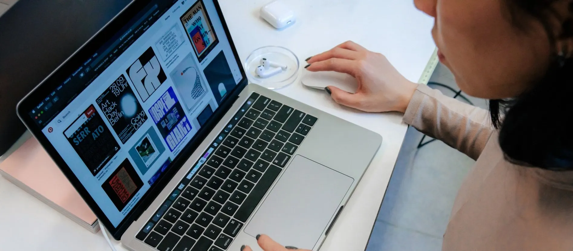 Een laptop met een webdesign op het scherm terwijl iemand de muis bedient